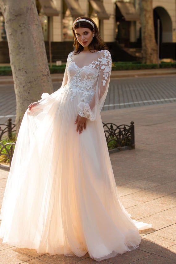 a woman in a wedding dress standing on the sidewalk