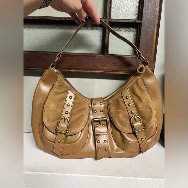 Brown/Tan Leather Hobo With Fun Soft Lime Green Interior And Multiple Pockets! Two On The Front Have Sueded Leather Flaps With Magnetic Snap Closures And One On The Back With Zipper. Inside Has One Zippered Pocket And Two Without. Studs And Buckle Hardware Has A Burnished/Antique Brass Look. Approximate Measurements Are 7” & 11”H, 4-5”D, And 16”W With 10” Strap Drop. New Without Tags. Beige Shoulder Bag With Brass Hardware, Brown Hobo Bag With Brass Hardware For Travel, Vintage Brown Hobo Bag For Errands, Brown Hobo Bag With Snap Closure, Casual Hobo Bag With Metal Hardware, Brown Hobo Bag With Brass Hardware, Brown Hobo Bag With Brass Hardware For Everyday Use, Beige Shoulder Bag With Brass Hardware For Everyday Use, Chic Brown Hobo Bag With Snap Closure