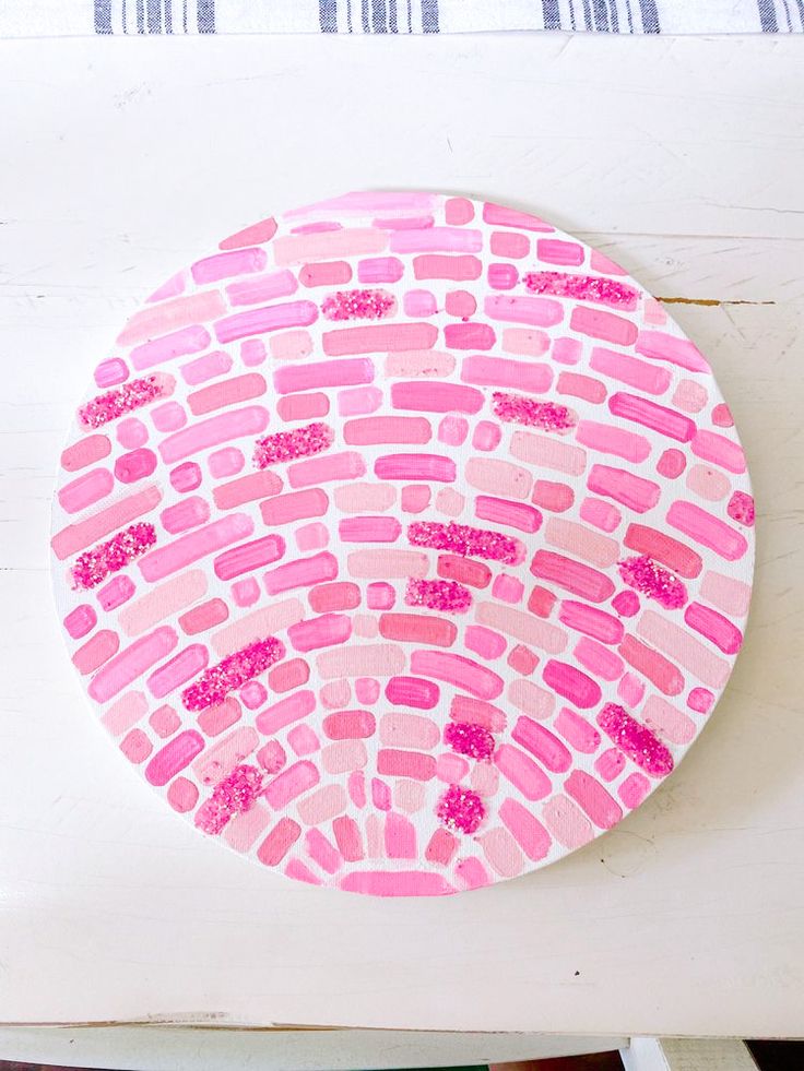 a paper plate with pink and red designs on it sitting on top of a table