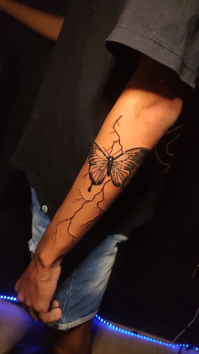 a man with a butterfly tattoo on his arm