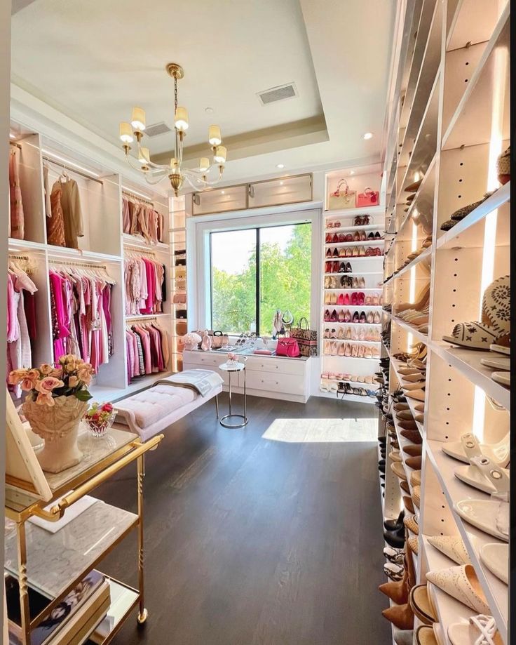 a room filled with lots of shoes and shelves full of clothes on display next to a window