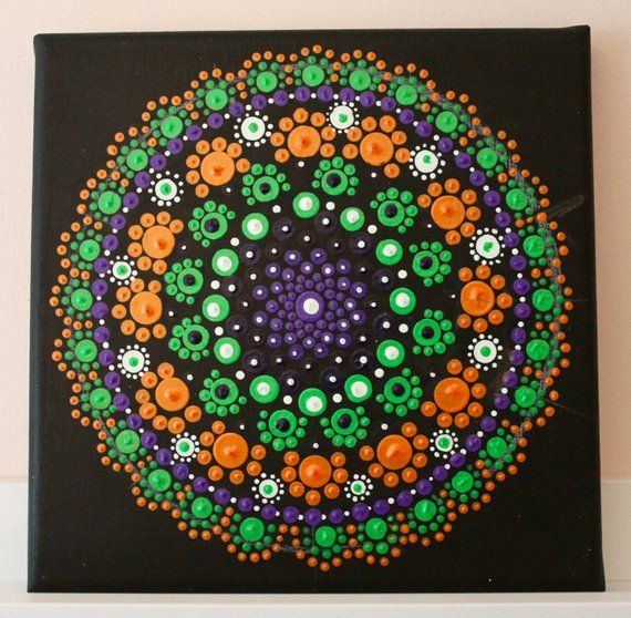 a colorful painting on a black canvas with orange, green and purple flowers in the center