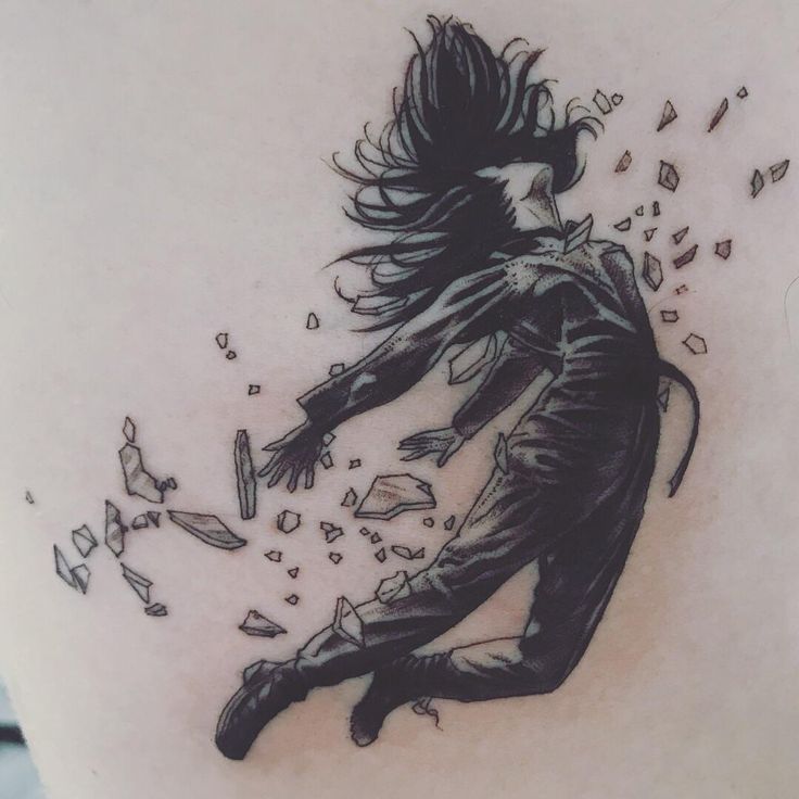 a woman's lower back tattoo with an image of a man falling from his arms