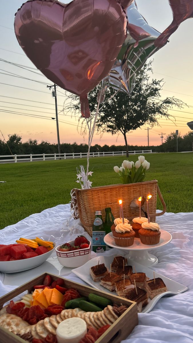 a table topped with lots of food and balloons