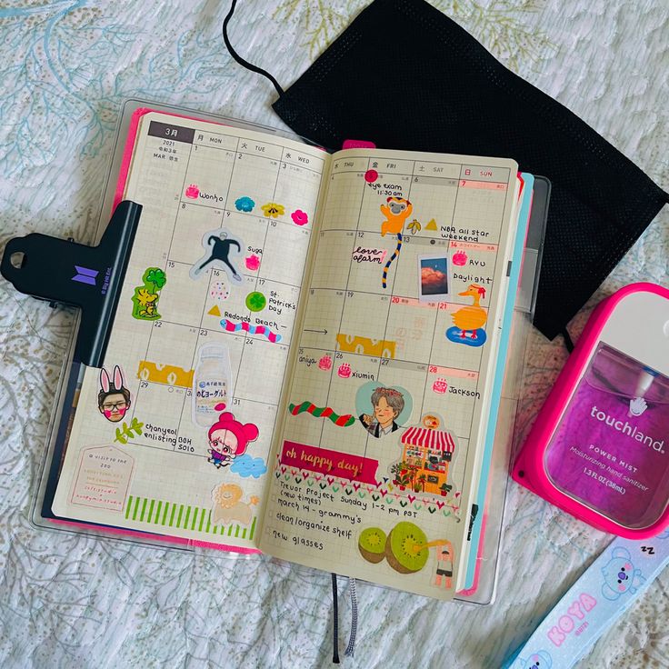 an open notebook sitting on top of a bed next to a toothbrush and other items