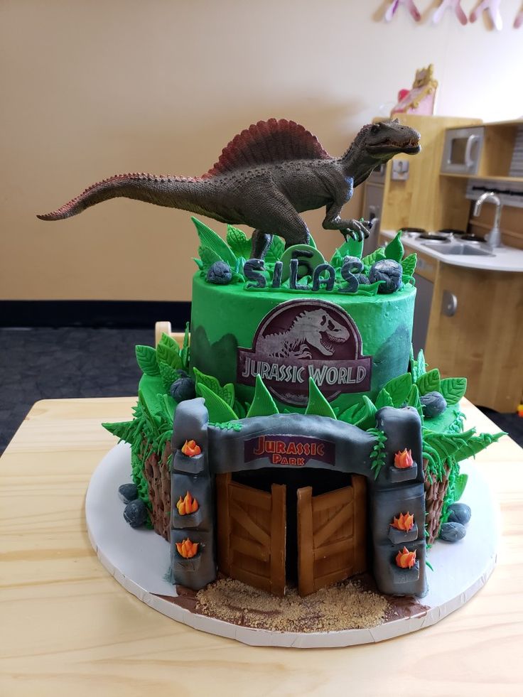 a dinosaur themed birthday cake on a table