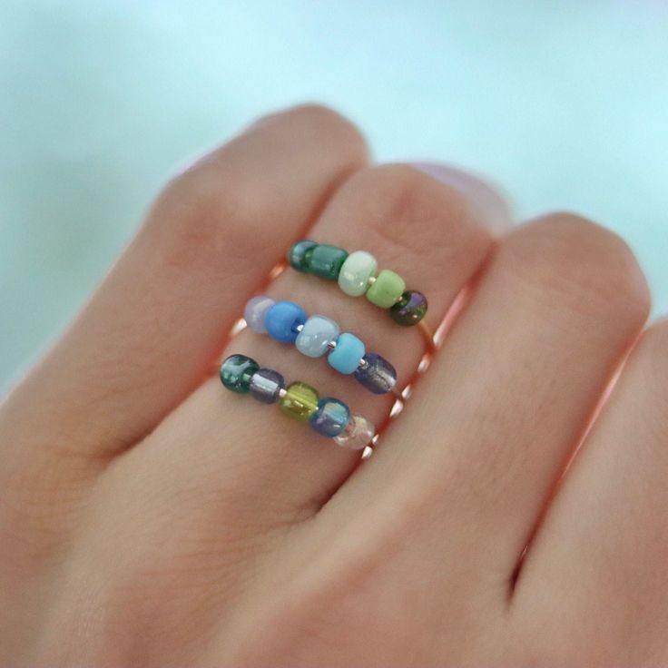 FOR MORE COLORS GO TO SHOP!! This set of three handmade wire, beaded fidget rings are perfect for any occasion and can be used in many ways. This set of bead spinner rings can serve as anti anxiety rings, focus rings for ADHD, worry rings, stress rings, or simply just cute, dainty, fashionable rings that can add a pop of color to your ensemble. The rings are constructed out of tarnish resistant wire in three available colors, and glass beads that are all unique in their special way! One order of this listing will supply three rings of your choosing. Simply let me know what bead combination you'd like with their respectful band color of SILVER, GOLD, or ROSE-GOLD. If you don't know what your ring size is, thats okay! There are plenty of ways to find out, but the benefit of this ring set, is Beaded Wire Rings, Fashionable Rings, Bead Spinner, Fidget Jewelry, Diy Elastic, Elastic Rings, Worry Ring, Fidget Rings, Three Rings