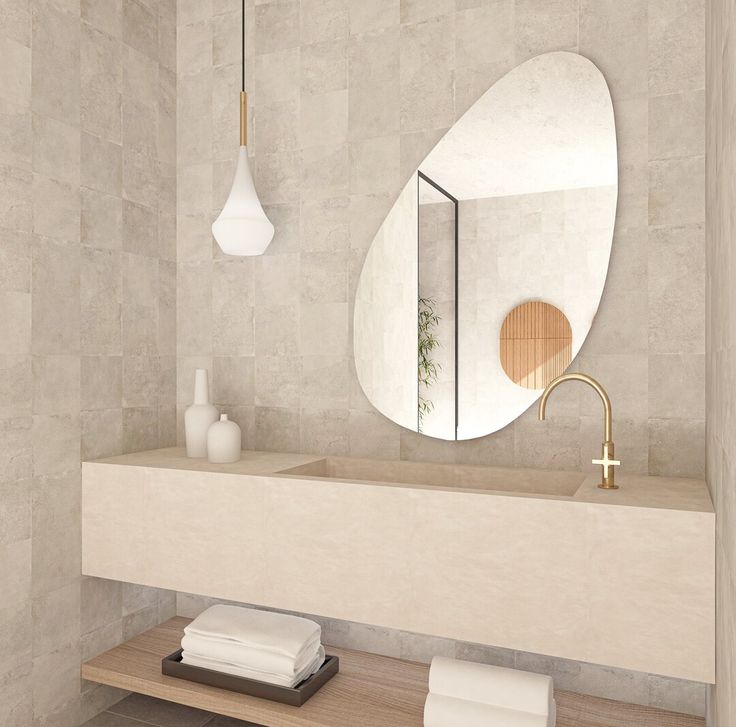 a bathroom with a sink, mirror and towels on the counter top in front of it