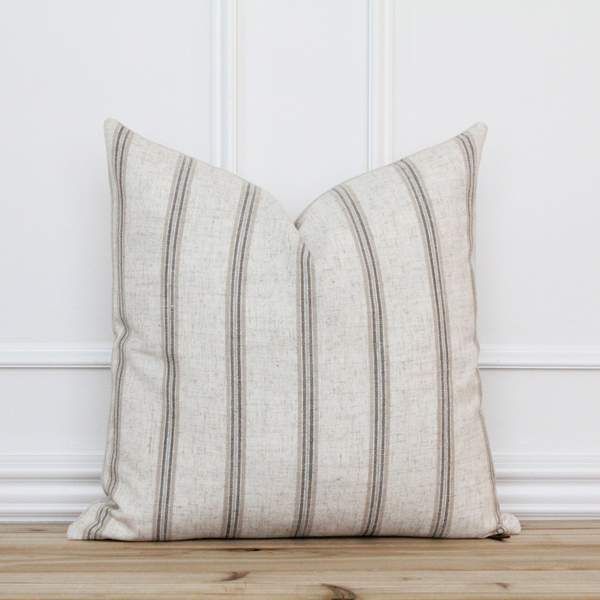 a pair of pillows sitting on top of a wooden floor next to a white wall