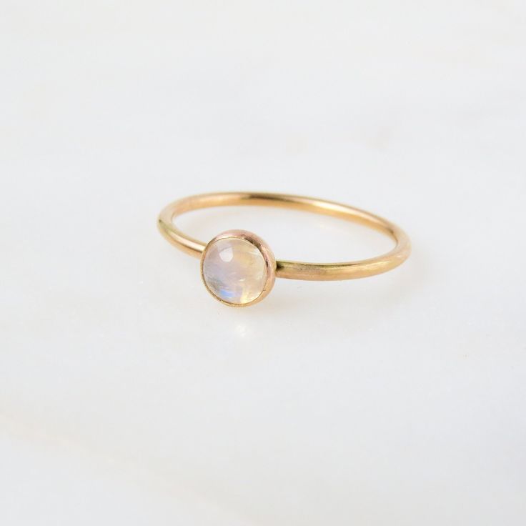 Our dainty Moonstone Ring features an absolutely stunning natural stone with reflects of blue. Moonstone is the birthstone for all our June-born babes. Don't know your ring size? Ring Size Guide or Buy Ring Sizer …………………………………. Details: Stone is Natural Rainbow Moonstone measuring 5mm Available in 14k Gold Filled or Sterling Silver Waterproof and can be worn everyday Size Inclusive and made to order About Your Jewelry If you are not wearing your jewelry it is best to store it in a cool, dry plac Gold Gemstone Ring, Blue Moonstone, Argentium Silver, Natural Rainbow, Ring Sizer, Moonstone Ring, Ring Size Guide, Rainbow Moonstone, Sterling Ring