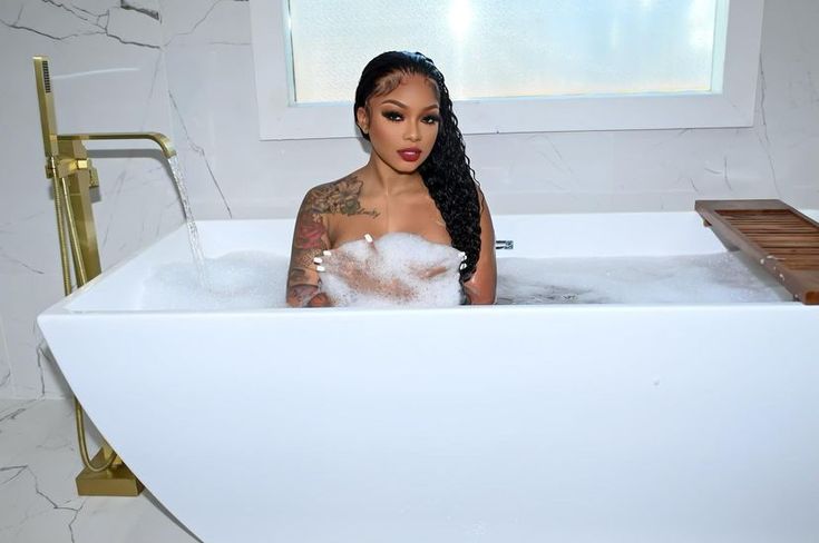 a woman sitting in a bathtub filled with foam