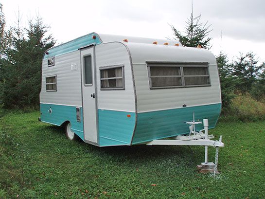 an old trailer is parked in the grass