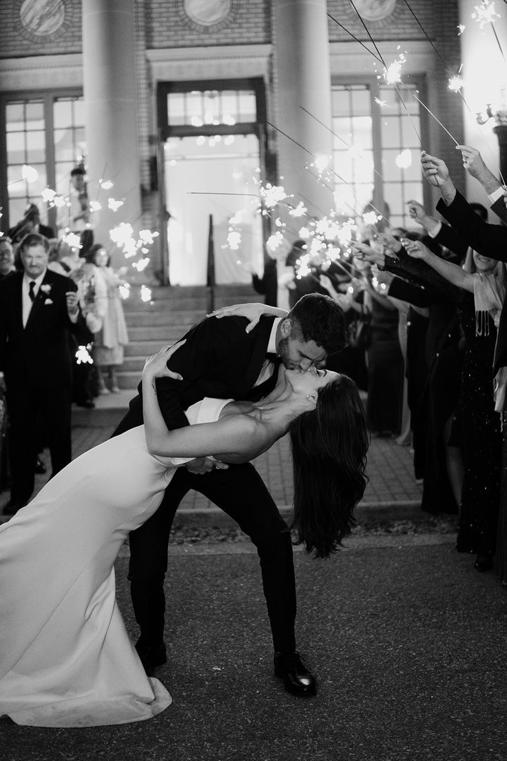 a bride and groom kissing while surrounded by sparklers