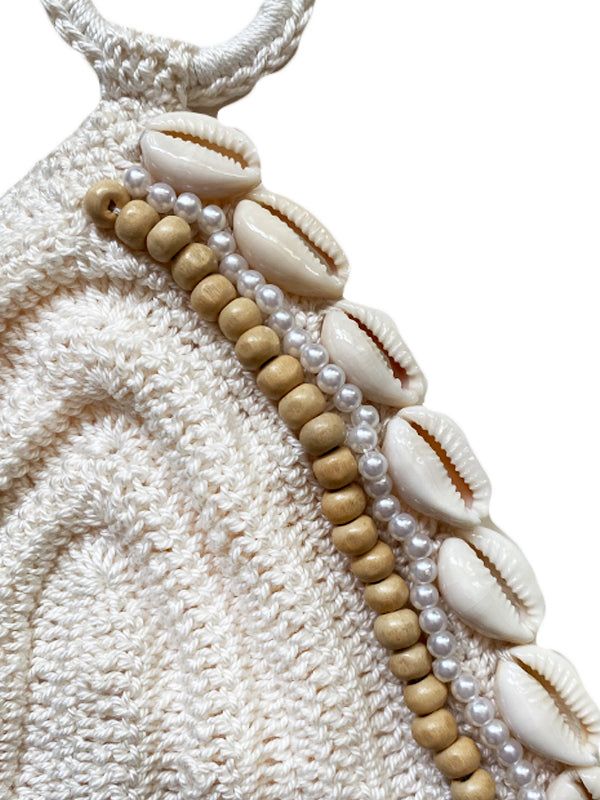 a white purse with shells and pearls on it