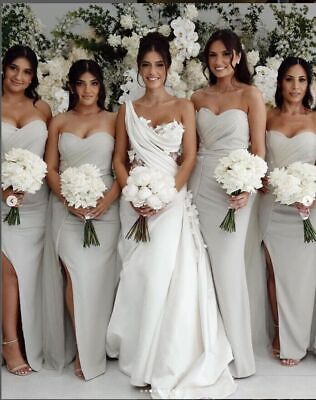 a group of women standing next to each other holding bouquets and posing for the camera