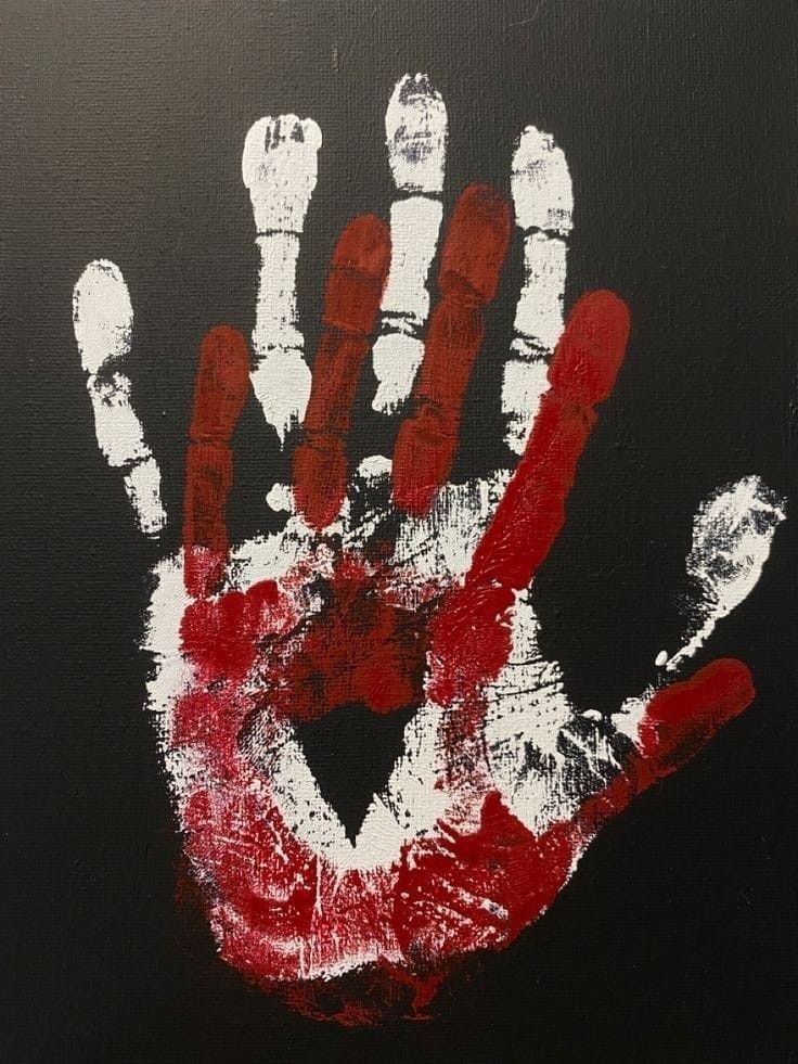 a hand painted with white and red paint on a black background is shown in the foreground