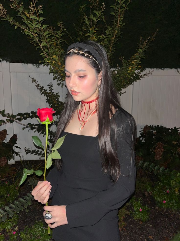 a woman with long hair holding a rose