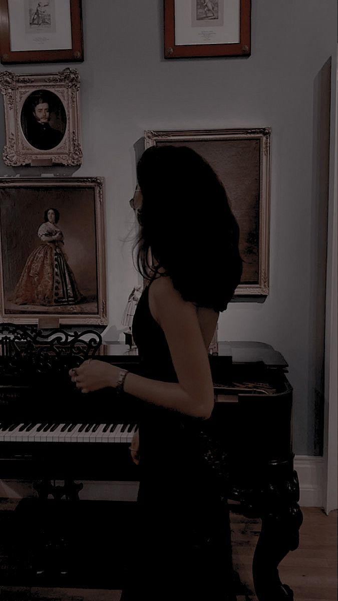 a woman standing in front of a piano