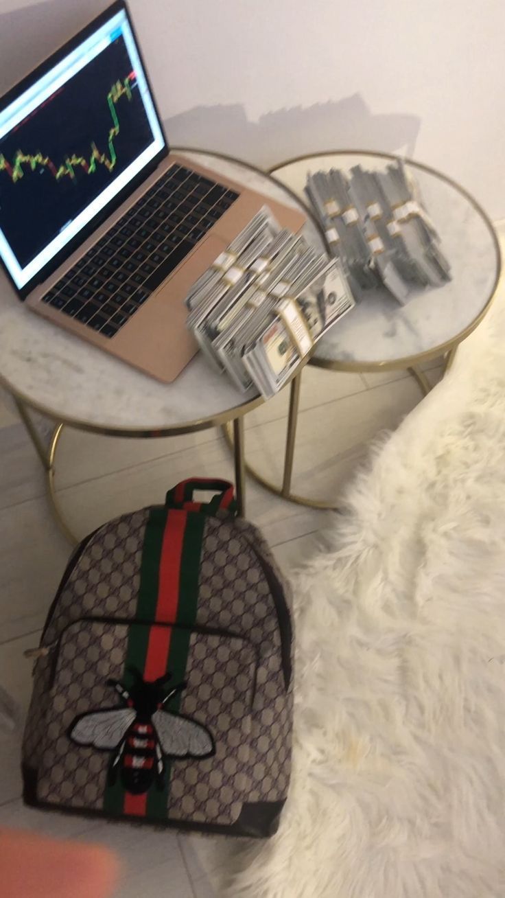 a laptop computer sitting on top of a table next to a purse and other items