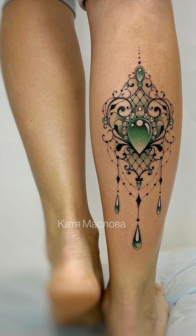 a woman's legs with a tattoo design on the bottom of her leg,