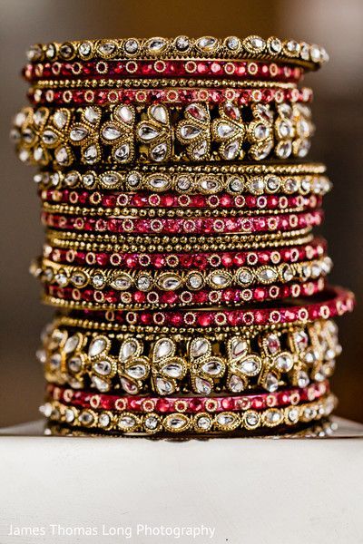 a stack of red and gold bracelets