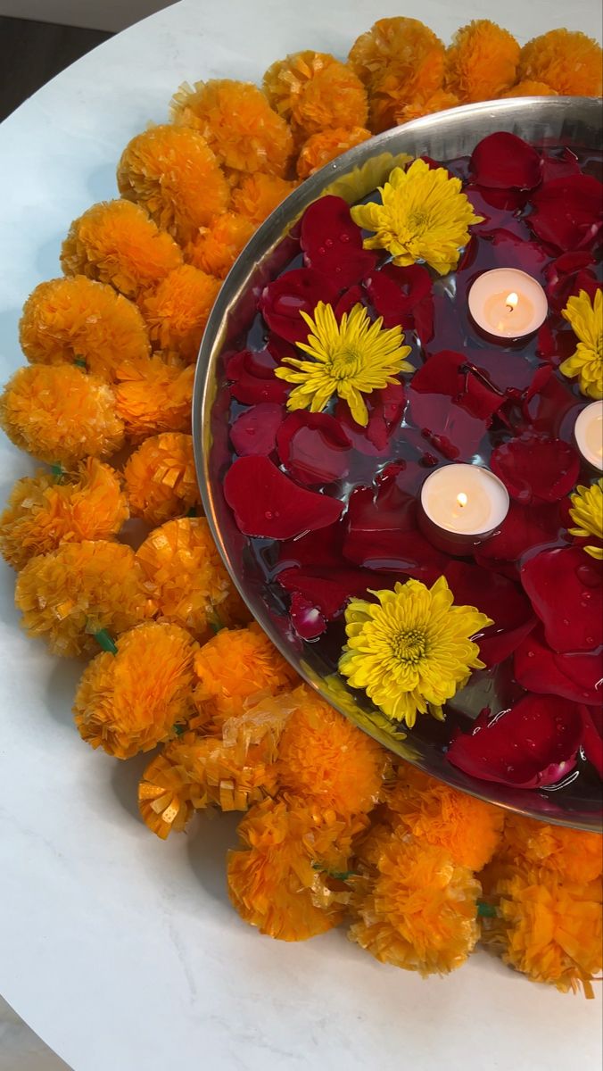 flowers and candles are floating in a bowl