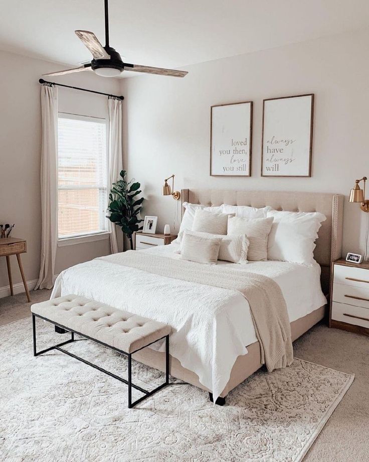 a bed room with a neatly made bed and two pictures on the wall above it