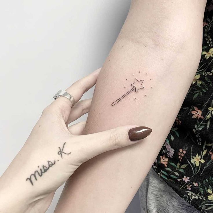 a woman's arm with a small star tattoo on the left side of her arm