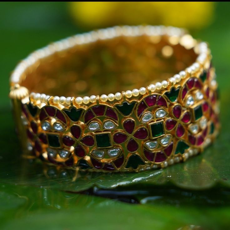 Description A vintage heirloom, our Indu silver bangle is inspired from timeless Indian jewelry featuring floral motifs. This bangle is infused with hundreds of kempu crystals that add a brilliant colors to the design. This bangle is part of Shruti Haasan edit, designed by Creative Director at Paksha. A great look for both weddings and special occasions. Product Information Materials used: 925 Silver with 1.0-microns Gold Plating Stones: Semi precious stones Length: 2.8 -6.5 cm Contains: Comes i Fusion Style Jeweled Kundan Bangle, Jeweled Kundan Fusion Bangle, Jeweled Kundan Bangle In Fusion Style, Ceremonial Kundan Fusion Bangle, Ceremonial Fusion Kundan Bangle, Festive Fusion Style Jeweled Bangle, Festive Fusion Jeweled Bangle, Temple Jewelry Style Jeweled Bangle For Wedding, Temple Style Jeweled Bangle For Weddings