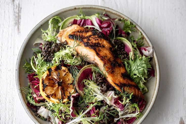 a salad with chicken and greens in a bowl