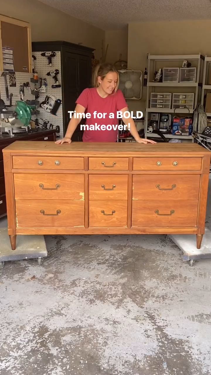 a woman standing behind a large wooden dresser