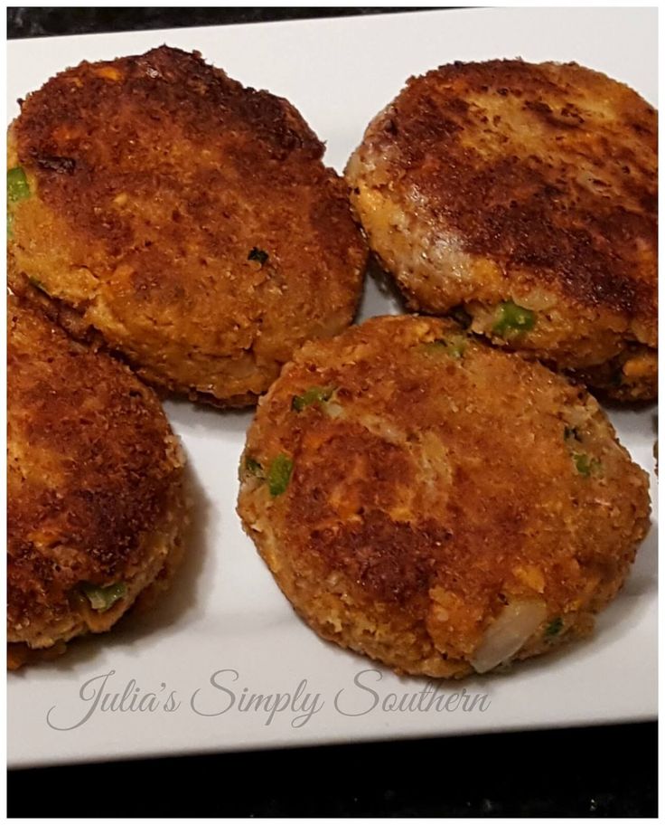 four crab cakes sitting on top of a white plate