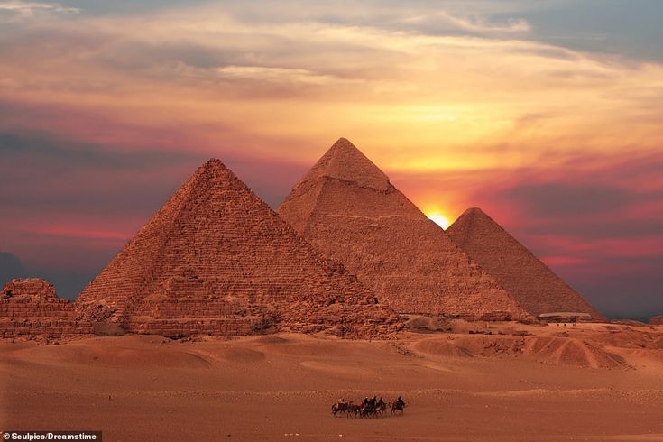 three pyramids in the desert at sunset with people on camels near them,