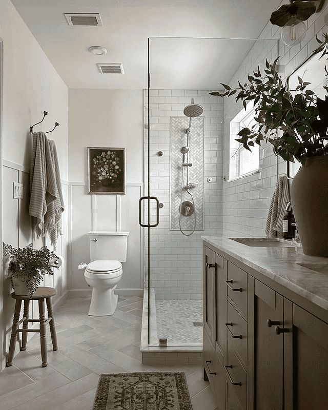 a black and white photo of a bathroom with a shower, toilet, sink and rug