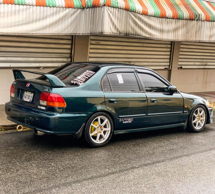 a green car parked in front of a building