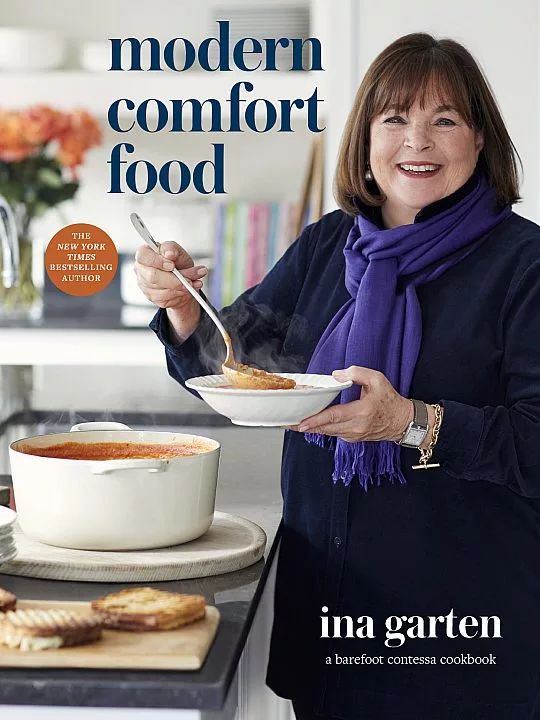 a woman holding a bowl of food on top of a counter next to a plate