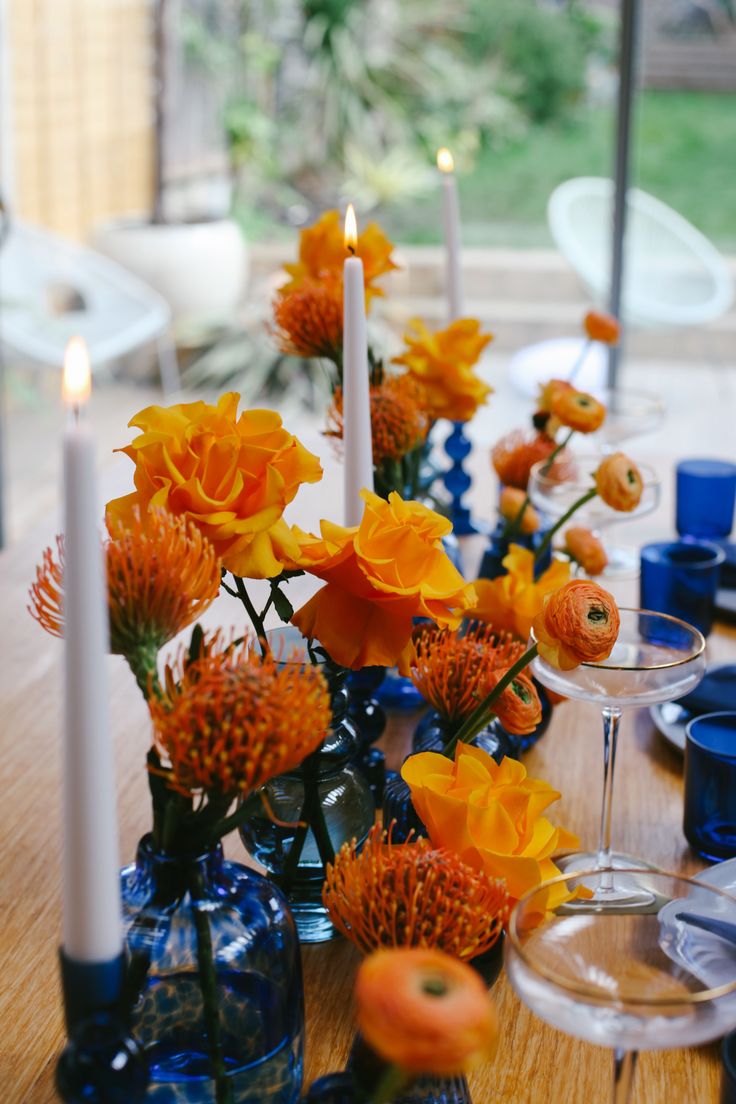 TablescapeBristol Blue GlassOrange table design Orange Blue Table Decor, Table Blue Decoration, Orange And Yellow Table Setting, Orange And Blue Party Ideas, Blue And Orange Event Decor, Blue And Orange Centerpieces Wedding, Cobalt Blue Table Setting, Orange And Blue Tablescape, Navy And Orange Table Setting