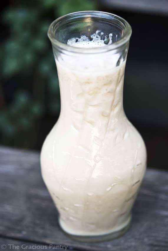 a glass vase filled with white liquid sitting on top of a wooden table