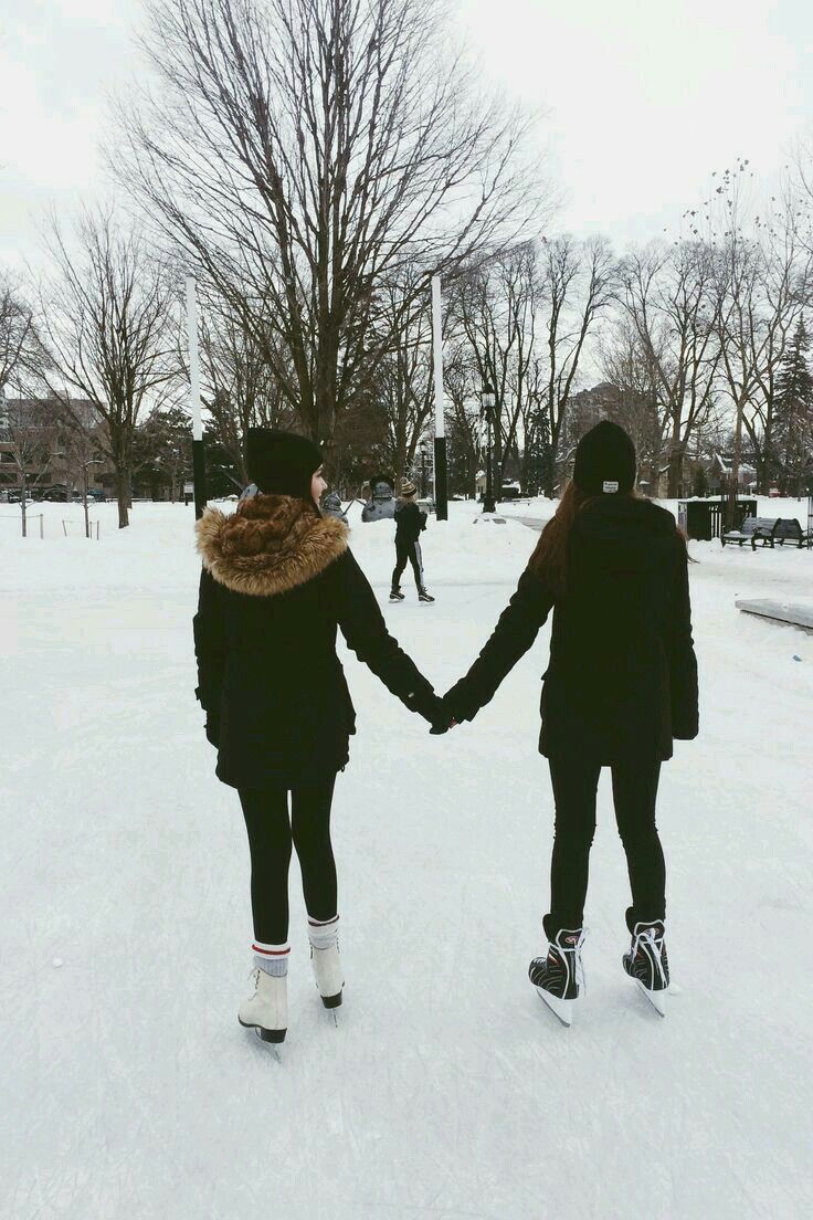 two people holding hands walking in the snow