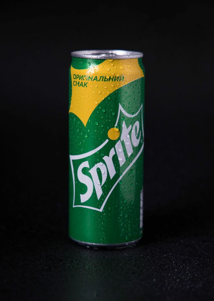 a can of sprite soda on a black surface