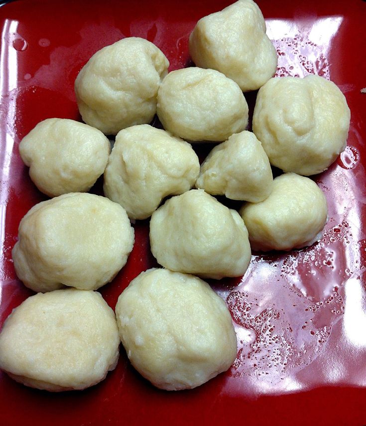 some dumplings are sitting on a red plate