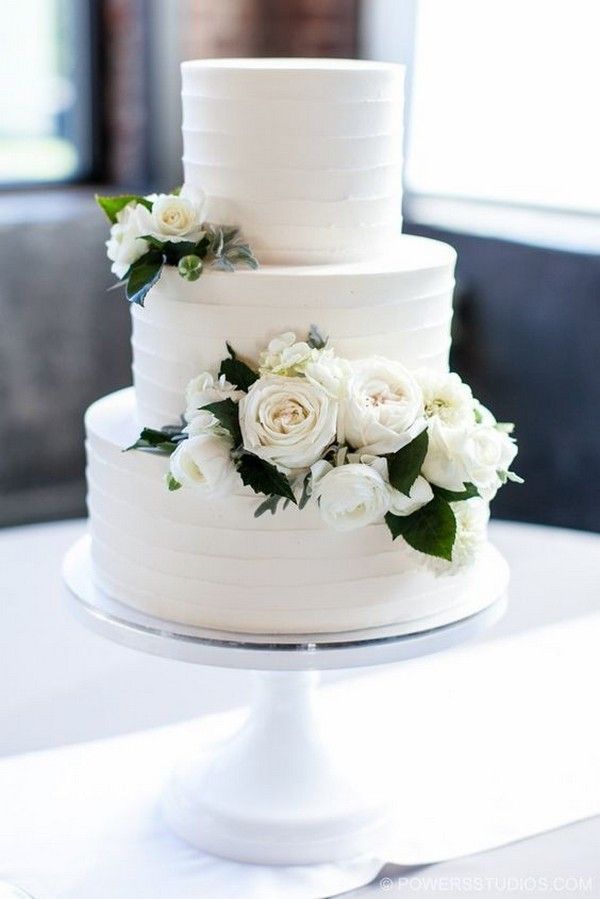 a white wedding cake with flowers on top