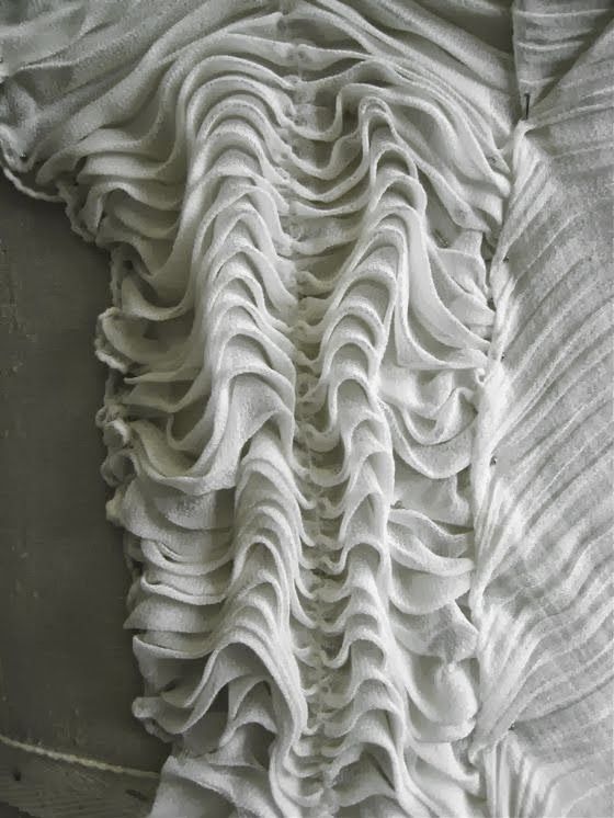 the back of a bed with ruffles on it