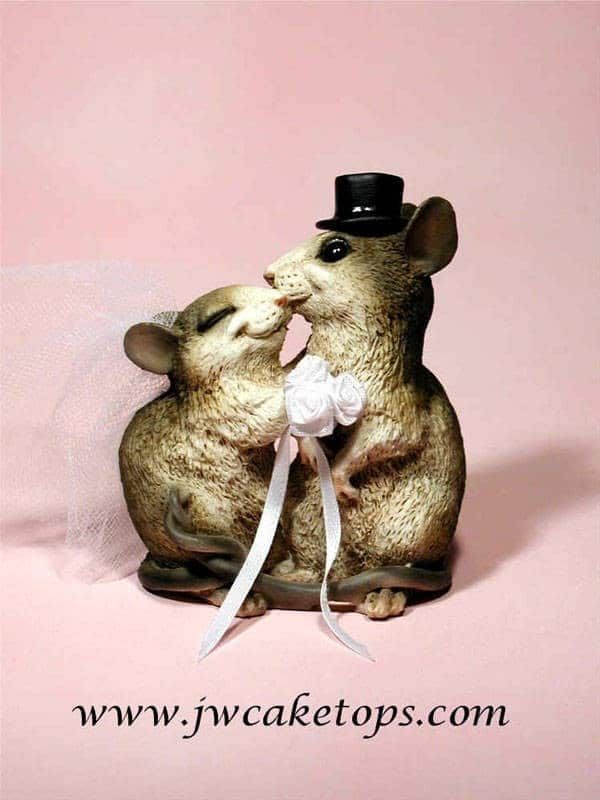 two little mice are kissing each other with a top hat on their heads and tails