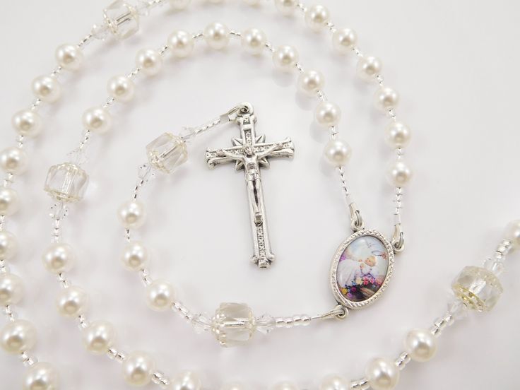 "- Personalized handmade rosary made with white Czech glass pearls and big white Czech cathedral glass beads - Choice of medals and letters - Comes with a velour pouch and gift box This white handmade baptism rosary is made with white Czech glass pearls and crystals and big antique looking Czech cathedral beads. It has a beautiful vintage look. Comes with your choice of Baptism, First Communion, Confirmation, or other medals. Read below for details. Over 80 colorful designs to choose from. Enter Silver Beaded Rosary For First Communion, Spiritual 8mm Beads Rosary For Baptism, Rosary Bracelet With 8mm Round Beads For Baptism, Elegant Round Beads Rosary For First Communion, Elegant White Rosary For First Communion, Adjustable Cross Rosary For First Communion, Adjustable White Rosary For First Communion, White Rosary Bracelet For First Communion, Adjustable Cross-shaped Rosary For First Communion