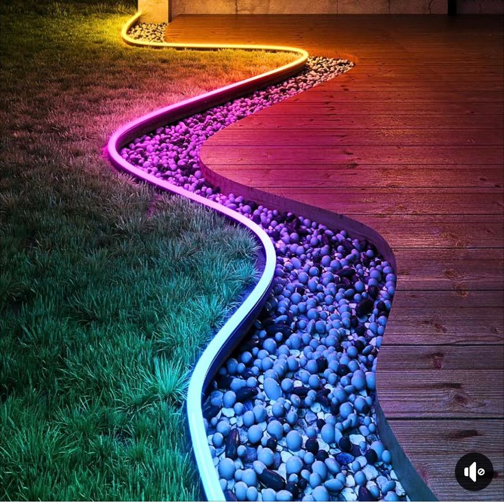 an illuminated pathway in the grass with rocks on it