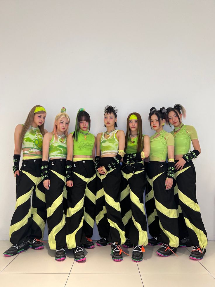 a group of young women standing next to each other in front of a white wall