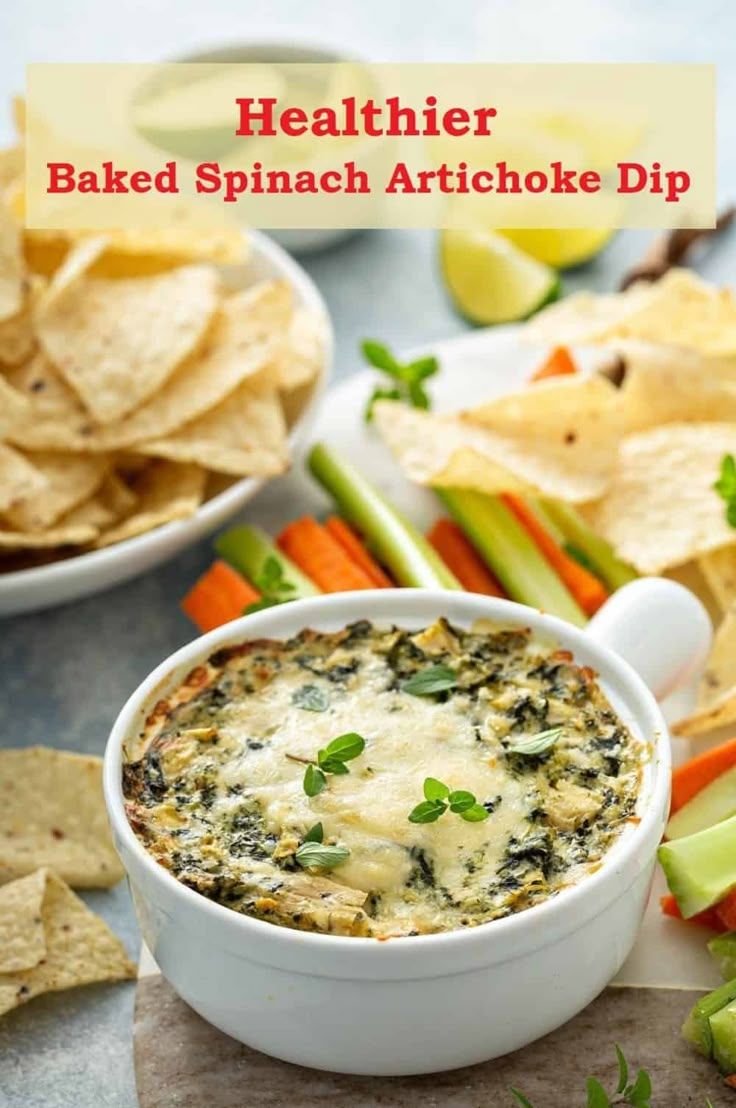 a white bowl filled with baked spinach artichoke dip surrounded by tortilla chips