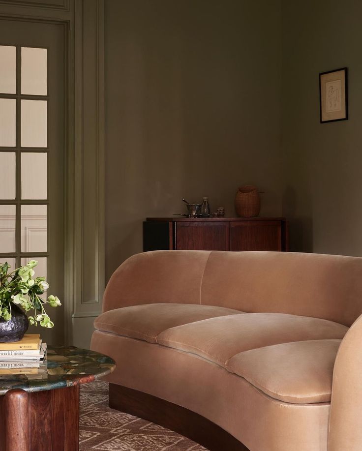 a living room with a couch, table and vase on the coffee table in front of it