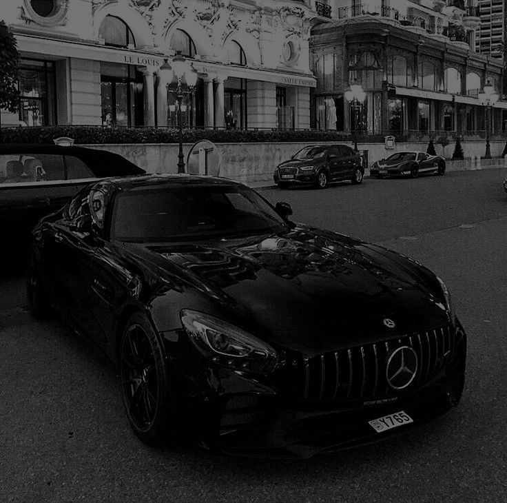 a black car parked on the street in front of a building